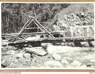 BULLDOG-WAU ROAD, NEW GUINEA. 1944-01-19. A SMALL TRESTLE BRIDGE CONSTRUCTED BY PERSONNEL OF THE 2/4TH FIELD SQUADRON OVER THE ELOA RIVER AT THE 19 1/2 MILE. THE OLD BRIDGE CAN BE SEEN IN THE ..