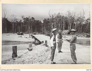 CAPE WOM, NEW GUINEA. 1945-11-14. WARRANT OFFICER 2 T. VINE, COMPANY SERGEANT MAJOR, 6 DIVISION PROVOST COMPANY (3) POSTING THE BRIDGE PICQUET AT URFIP CREEK. CORPORAL P. TURNER (1) IS RELIEVING ..