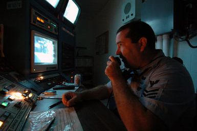 US Navy (USN) Boiler Technician First Class (BT1) Troy Potter, an Instructor at the Naval Submarine Training Center Pacific (NSTCP), located at Navy Base Pearl Harbor, Hawaii (HI), maintains communications from the control room of a wet trainer located on Ford Island, Hawaii. Instructors in the control room monitor safety of students and regulate the amount of flooding to the trainer