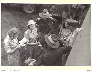 BORAM AIRSTRIP, WEWAK AREA, NEW GUINEA. 1945-09-28. MAJOR T. FOGARTY (3), MAJOR D.S.I. BURROWS (4) AND CAPTAIN C.W.A. PARSONS (5), MEMBERS OF HEADQUARTERS 6 DIVISION, GREETING THE DARYA COLLIN ..