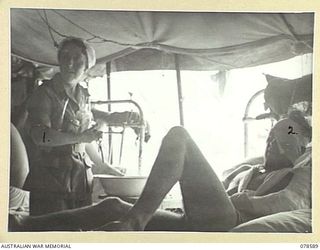 BOUGAINVILLE ISLAND. 1945-01-23. QFX43182 SISTER L.M. KAVNEY CARRYING OUT WARD DUTIES AT THE 2/1ST AUSTRALIAN GENERAL HOSPITAL