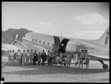 Passengers stand alongside a C47 transport aircraft, Rarotonga airfield, Cook Islands