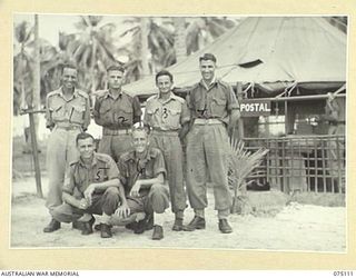 MILILAT, NEW GUINEA. 1944-08-07. MEMBERS OF THE STAFF IN FRONT OF THE TENT OFFICE OF THE 5TH DIVISION POSTAL UNIT. IDENTIFIED PERSONNEL ARE:- NX151763 PRIVATE H. FLOHM (1); QX2662 CORPORAL S.V. ..