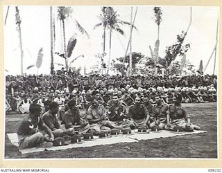 KARAVIA BAY, NEW BRITAIN. 1945-10-23. MAJOR GENERAL K.W. EATHER, GENERAL OFFICER COMMANDING 11 DIVISION, VISITED THE INDIAN EX-PRISONER OF WAR CAMP AT KARAVIA BAY. SHOWN, AN INDIAN CHOIR SINGING ..