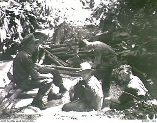 THE SOLOMON ISLANDS, 1945-05-02. AUSTRALIAN SOLDIERS ON PATROL REST BY A CREEK ON BOUGAINVILLE ISLAND. (RNZAF OFFICIAL PHOTOGRAPH.)