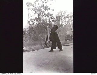 TOROKINA, BOUGAINVILLE. 1945-11-03. ENTERTAINERS CORPORAL S. SHIPWAY AND CORPORAL L. SHIPWAY, TRAPEZE ARTISTS, LIMBERING UP IN PREPARATION FOR THE SHOW TO BE STAGED FOR TROOPS BY MEMBERS OF THE ..
