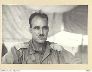 WUNUNG PLANTATION, JACQUINOT BAY, NEW BRITAIN. 1945-03-02. MEMBERS OF THE ARMY NURSING SERVICE OF THE 105TH CASUALTY CLEARING STATION WATCHING ONE OF THE UNIT NATIVE BOYS COMBING HIS HAIR. ..