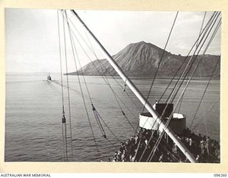BLANCHE BAY, RABAUL, NEW BRITAIN. 1945-09-10. THE DESTROYER HMAS VENDETTA LEADING THE HMAS MANOORA PAST THE VOLCANO, SOUTH DAUGHTER, INTO SIMPSON HARBOUR. THE MANOORA CARRIED TROOPS FOR THE ..