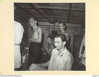 LAE, NEW GUINEA. 1944-07-25. MEMBERS OF THE 3RD ARMOURED DIVISION CONCERT PARTY, AUSTRALIAN ARMY AMENITIES SERVICE INSIDE A MOBILE DRESSING ROOM APPLYING TOUCHES OF "GLAMOUR". IDENTIFIED PERSONNEL ..