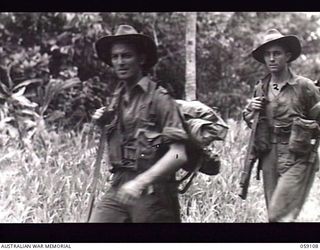 BUKAUA, NEW GUINEA. 1943-10-18. V125091 PRIVATE (PTE) W. G. ROBINS (LEFT) AND V185554 PTE A. P. PAGE OF THE 29/46TH AUSTRALIAN INFANTRY BATTALION MARCHING OFF TO ASSIST IN CLEARING THE JAPANESE ..