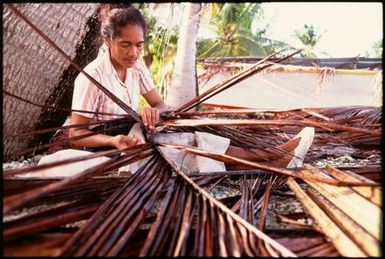 Woman with dried palm fronds, Cook Islands
