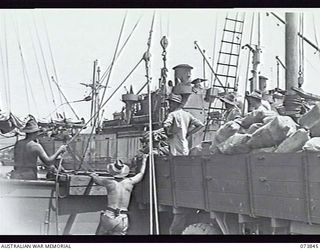 LAE, NEW GUINEA. 1944-06-17. AUSTRALIAN MAIL BEING LOADED INTO THE AK95, A SHIP MANNED BY 12TH WATER TRANSPORT OPERATING COMPANY, ROYAL AUSTRALIAN ENGINEERS, WHICH IS BOUND FOR MADANG