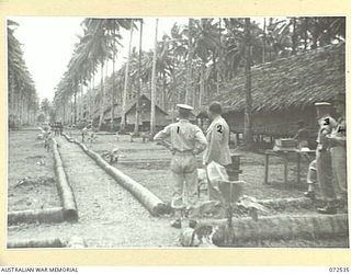 MILNE BAY, NEW GUINEA. 1944-04-20. THE HONOURABLE E.J. WARD, MINISTER FOR EXTERNAL TERRITORIES IN THE AUSTRALIAN GOVERNMENT (2), WITH WARRANT OFFICER II, K.M. CHAMBERS, ASSISTANT DIRECTOR OF NATIVE ..