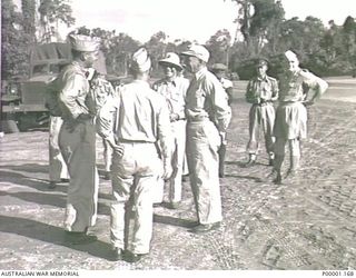 THE SOLOMON ISLANDS, 1945. UNITED STATES AND ALLIED OFFICERS TALKING WITH AMERICAN MAJOR GENERAL R.J. MITCHELL AS HE PREPARES TO LEAVE BOUGAINVILLE ISLAND. (RNZAF OFFICIAL PHOTOGRAPH.)