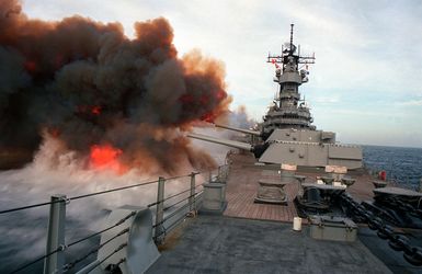 Smoke billows from the muzzles of the Mark 7 16-inch/50-caliber guns in each of the three main gun turrets aboard the battleship USS MISSOURI (BB-63) after the ship fired multiple slavos during exercise RimPac "90 near Hawaii