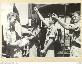 LANGEMAK BAY, NEW GUINEA. 1944-10-23. SIGNALLERS BENDING FLAGS AND RECEIVING MESSAGES ABOARD THE RAN CORVETTE, GYMPIE