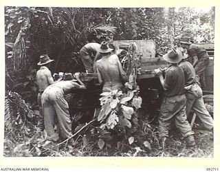 WEWAK AREA, NEW GUINEA, 1945-05-30. TROOPS OF 2/11 INFANTRY BATTALION CHANGING THE TRAY OF A JAPANESE TRUCK TO THE CHASSIS OF ANOTHER ONE WHICH HAD A COMPARATIVELY GOOD ENGINE AND LOW MILEAGE. THE ..