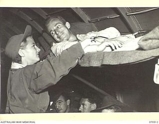 PORT MORESBY, PAPUA, 1944-02. LIEUTENANT "WOODIE" A. RAY, OF JEFFERSON, GEORGIA, (1) AN AMERICAN NURSE, ATTENDING PRIVATE COLIN BELL (2) A WOUNDED AUSTRALIAN WHO IS BEING FLOWN BACK WITH OTHER ..