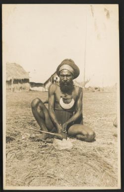 A Hagen native sharpening his stone axe on a special rubbing stone, Central New Guinea, 1933