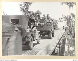 BOUGAINVILLE. 1945-05-30. VEHICLES OF 2/11 FIELD REGIMENT, ROYAL AUSTRALIAN ENGINEERS, CROSSING THE NEWLY CONSTRUCTED SAVIGE BRIDGE OVER THE JABA RIVER. THIS BRIDGE, MEASURING 620 FEET LONG AS A ..