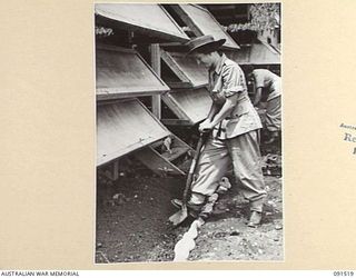 LAE, NEW GUINEA. 1945-05-08. NF444296 LANCE CORPORAL Norma Lillian TAYLOR (1), DIGGING IN HER GARDEN IN FRONT OF THE SLEEPING QUARTERS SHORTLY AFTER HER ARRIVAL AT THE NEWLY CONSTRUCTED AWAS ..