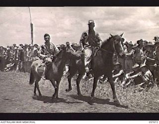 SOPUTA, NEW GUINEA. 1943-10-09. WX3835 CRAFTSMAN M. R. FITZGERALD ON "LUCY" AN ENTRANT IN THE PONY RACE, BEING LED TO THE START BY THE CLERK OF THE COURSE, NX78766 BOMBARDIER G. H. LAHAY, ..