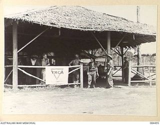 LAE AREA, NEW GUINEA. 1944-12-20. THE YMCA HUT. FROM THIS HUT IS PROVIDED FACILITIES FOR THE REST AND RECREATION OF TROOPS, THE SUPERVISION OF HUTS AND REFRESHMENTS TO WORK COYS AND FORWARD AREA ..