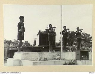 LAE, NEW GUINEA. 1944-11-05. BUGLERS OF THE ROYAL PAPUAN CONSTABULARY SOUNDING THE "LAST POST" AT THE CONCLUSION OF THE SOLEMN REQUIEM MASS AT THE LAE WAR CEMETERY