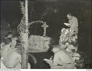 KIRIWINA TROBRIAND ISLANDS, PAPUA. 1944-02. 207139 LEADING AIRCRAFTMAN H. W. MOSES RAAF OF NEWTOWN, NSW, READS THE LESSON FROM THE FIRST BOOK OF KINGS DURING A SERVICE IN THE CORAL CATHEDRAL, ONE ..