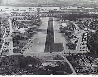 OROTE POINT, GUAM. 1945. OROTE AIRFIELD'S RUNWAY IS SURROUNDED BY A CITY OF STRICTLY FUNTIONAL QUONSET HUTS, WORKSHOPS, TENTS AND STORES DUMPS. THERE ARE OVER 200 AIRCRAFT IN THE PHOTOGRAPH AND ..