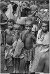Mortuary ceremony, Omarakana: children, boy (l) wears cross medal of type given by Allied forces to local men during World War II