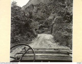 WAU - LAE ROAD, NEW GUINEA, 1944-02-26. AT THIS POINT THE ROAD, WIDENED TO TWENTY FEET BY THE 1ST MECHANICAL EQUIPMENT PLATOON, 2/1ST RAILWAY CONSTRUCTION COMPANY, (MECHANICAL EQUIPMENT), ROYAL ..