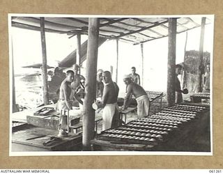 DUMPU, RAMU VALLEY. 1943-11-20. BAKEHOUSE SCENE AT NO. 2 SECTION, NO. 3 PLATOON, 4TH AUSTRALIAN FIELD BAKERY, SHOWING THE BAKERS MAKING BREAD ROLLS