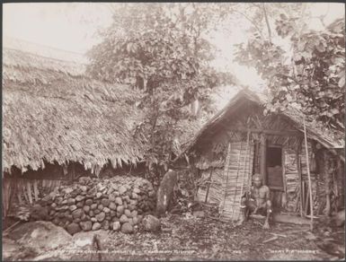 A man sitting next to a rock altar at Ferasiboa, Malaita, Solomon Islands, 1906 / J.W. Beattie
