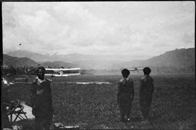 Three men with a bi-plane and  mono plane in background, New Guinea, ca. 1935 / Sarah Chinnery