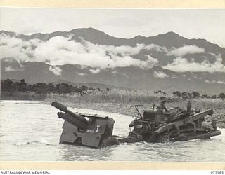 EVAPIA RIVER, NEW GUINEA, 1944-03-15. A BULLDOZER FROM THE 4TH FIELD REGIMENT, ROYAL AUSTRALIAN ENGINEERS, HAULING A 25-POUNDER ARTILLERY GUN ACROSS THE RIVER, THE APPARENT SOLUTION TO MOVING THE ..