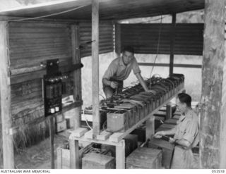 SOGERI VALLEY, NEW GUINEA, 1943-06-26. NX117972 SIGNALMAN B. G. WALKER (LEFT) AND NX151414 SERGEANT W. D. WELLS AT WORK IN THE BATTERY CHARGING SECTION OF THE NEW GUINEA FORCE SCHOOL OF SIGNALS