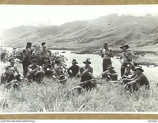 WALINGAI BEACH, NEW GUINEA. 1944-01-02. MEMBERS OF THE 15TH PLATOON, C COMPANY, 2/48TH INFANTRY BATTALION ENJOYING A CUP OF TEA. SHOWN ARE: NX8727 LIEUTENANT M. F. ROBINSON (1); SX10909 PRIVATE W. ..