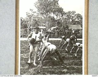 NEW GUINEA. 1943-11-20. A COMPETITOR IN THE TUNNEL BALL CONTEST RACING FORWARD WITH THE BALL AT THE CHAMPIONSHIPS SPORTS MEETING ORGANISED BY THE 18TH AUSTRALIAN INFANTRY BRIGADE TO CELEBRATE THE ..