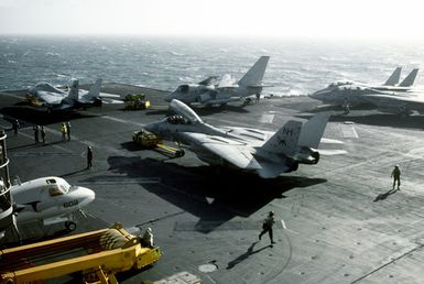 An S-3A Viking aircraft and two F-14A Tomcat aircraft are respotted near the stern of the nuclear-powered aircraft carrier USS Abraham Lincoln (CVN-72) during flight operations near Hawaii. The Tomcat at left is from Fighter Squadron 114 (VF-114); the Tomcat at center is from Fighter Squadron 213 (VF-213)