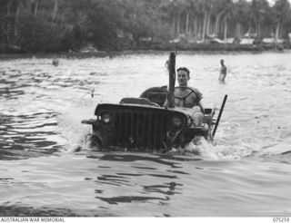 MILILAT, NEW GUINEA. 1944-08-13. VX137730 WARRANT OFFICER II, N.W. GRANGER (1) DRIVING A WATERPROOFED JEEP ACROSS A WIDE CREEK NEAR THE CAMP OF THE ELECTRICAL AND MECHANICAL ENGINEERS, ..