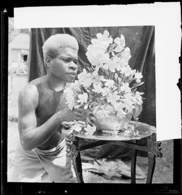 Man with a bowl of flowers on a small table, Rabaul, New Guinea, ca. 1936 / Sarah Chinnery