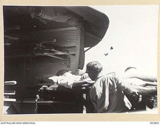 LAE, NEW GUINEA. 1945-06-09. SIGNALMAN S.R. SENIOR (1), BEING MOVED FROM WARD TO AMBULANCE AT 2/7 GENERAL HOSPITAL FOR TRANSFER TO THE HOSPITAL SHIP MANUNDA