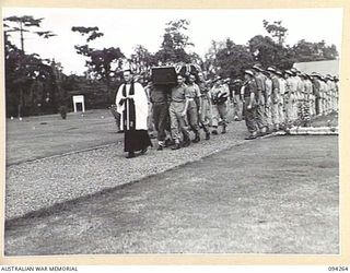 LAE AREA, NEW GUINEA. 1945-07-23. PALL BEARERS CARRYING THE REMAINS OF PRIVATE B.J. SMITH THROUGH A GUARD OF HONOUR COMPRISING FRIENDS OF THE DECEASED, DURING A FUNERAL SERVICE CONDUCTED AT LAE WAR ..