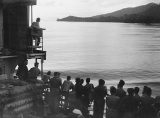 AT SEA, 1945-03-30. 2/48 INFANTRY BATTALION PERSONNEL WITH HEADQUARTERS 26 INFANTRY BRIGADE TROOPS LINING THE PORT RAIL OF THE VAN HEUTSZ AS THE VESSEL NEARS MILNE BAY DURING THEIR MOVEMENT FROM ..