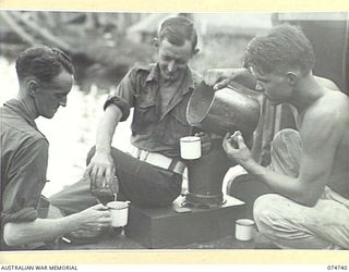 MADANG, NEW GUINEA. 1944. AUSTRALIAN AND AMERICAN TROOPS PREPARING TO ENJOY A CUP OF COFFEE ABOARD THE COURIER BARGE OF THE 593RD UNITED STATES BARGE COMPANY DURING A SHORT STOP WHILE ON THEIR WAY ..