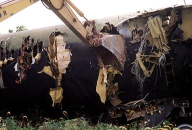 A ditch digging machine tears at the fuselage of a B-52D Stratofortress bomber aircraft, one of three discarded in accordance with the SALT II treaty between the United States and the Soviet Union