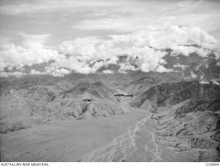 NEW GUINEA. 1944-02-27. IN FLIGHT OVER RUGGED MOUNTAINOUS TERRAIN, VULTEE VENGEANCE DIVE BOMBER AIRCRAFT OF NO. 24 SQUADRON RAAF FLY OVER THE UNI RIVER ON THEIR RETURN FROM AN AIR RAID ON THE ..