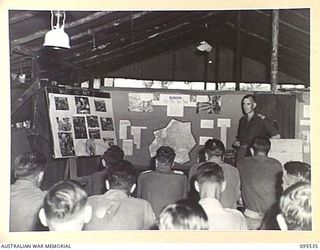 JACQUINOT BAY, NEW BRITAIN, 1945-08-25. CAPTAIN H.P. CARTER, SENIOR INSTRUCTOR, LECTURING TO STUDENTS IN A HUT AT NO. 2 MOBILE TEAM LAND HEADQUARTERS SCHOOL OF ARMY EDUCATION