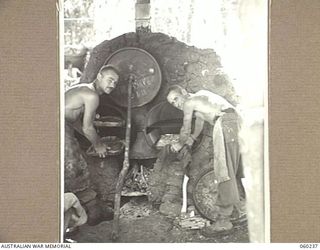 DUMPU, NEW GUINEA, 1943-11-05. SX4745 SERGEANT E. S. LOWE OF UNDULYA, SA (LEFT), AND SX4515 LANCE CORPORAL W. FERRIS OF ST PETERS, SA (RIGHT), COOKS OF THE 2/6TH AUSTRALIAN FIELD AMBULANCE, ..